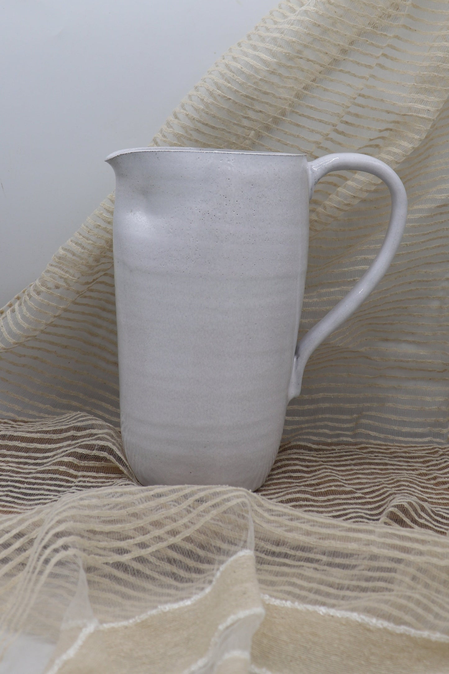 Grey clay pitcher in white