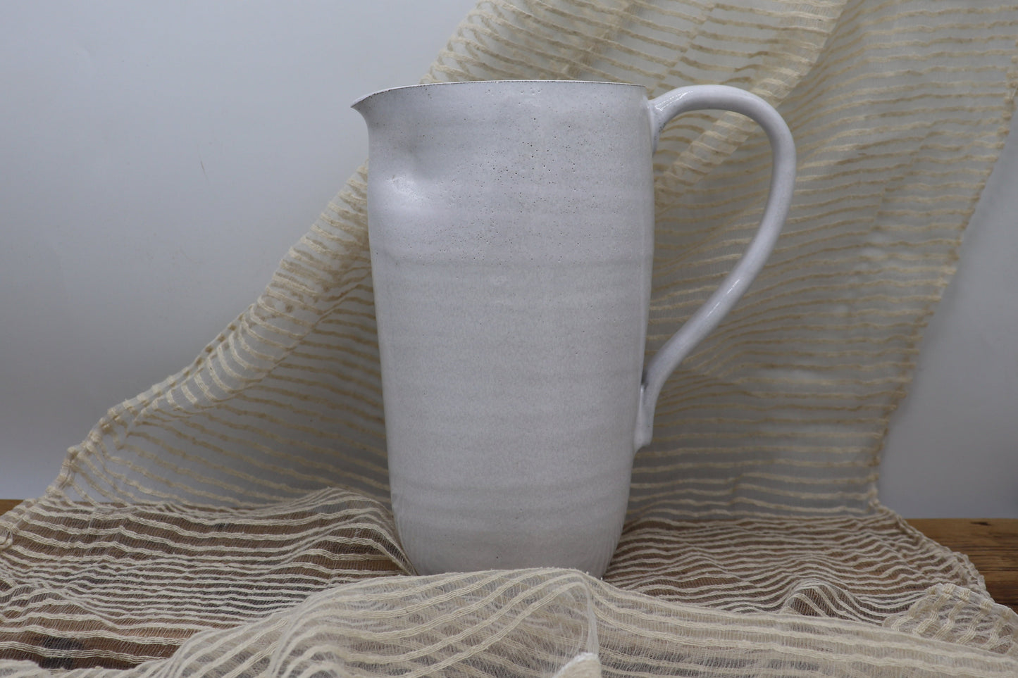 Grey clay pitcher in white