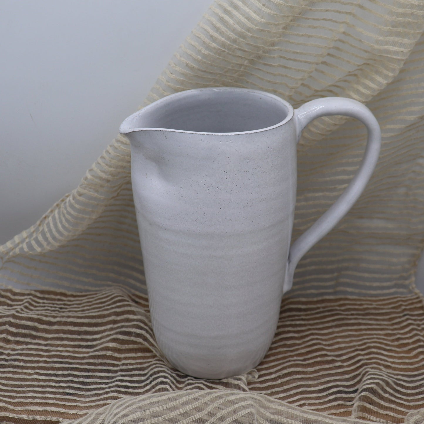 Grey clay pitcher in white