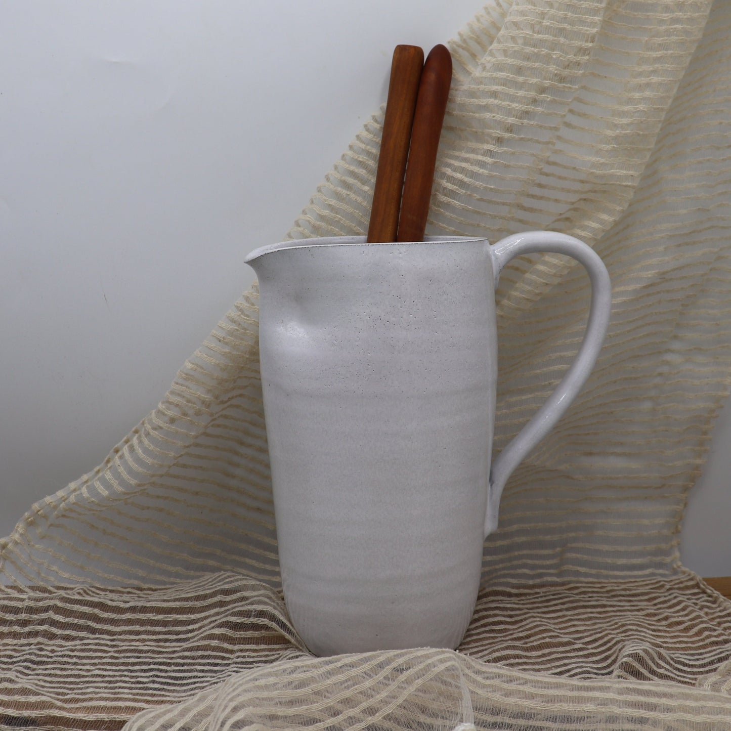 Grey clay pitcher in white