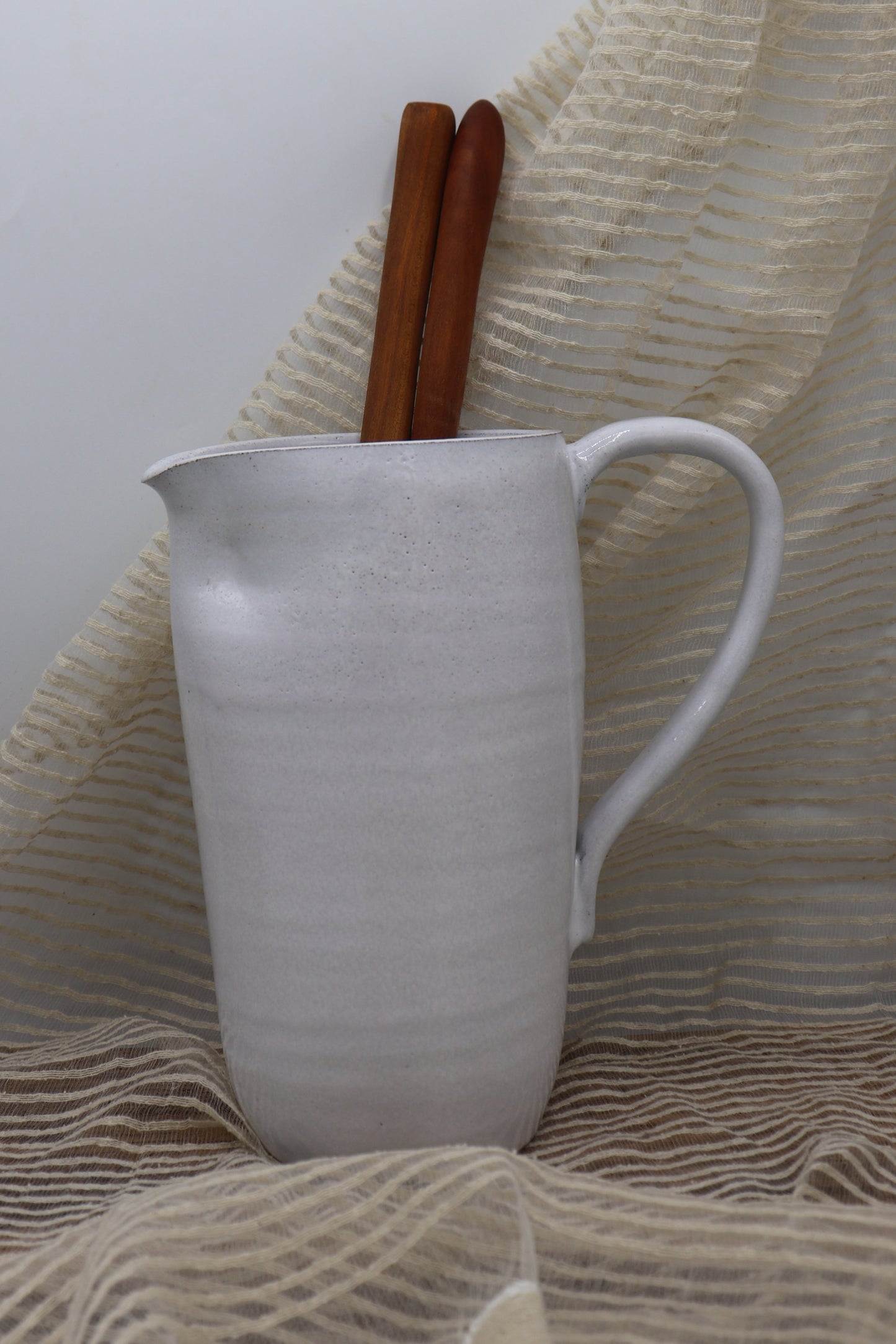 Grey clay pitcher in white