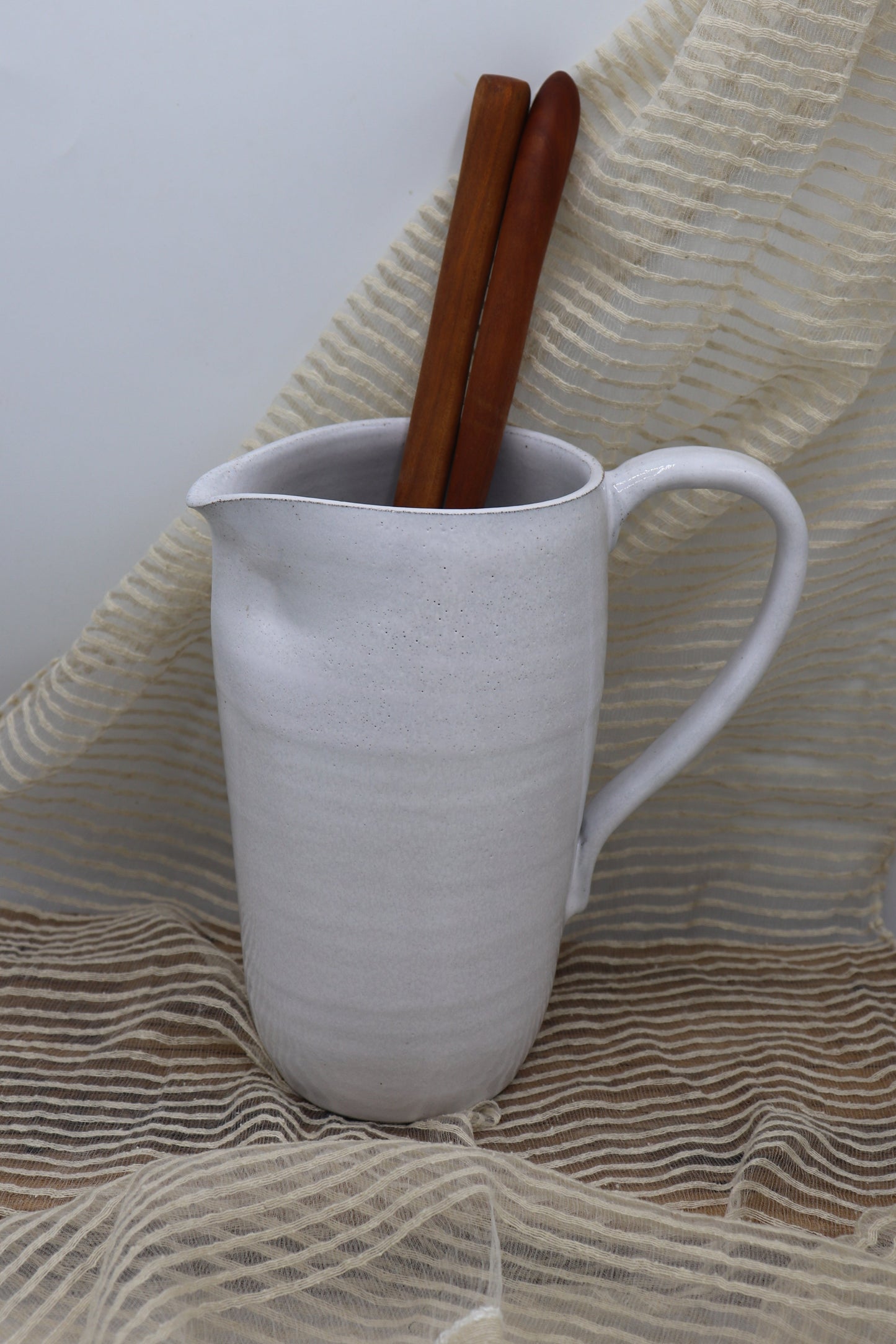 Grey clay pitcher in white