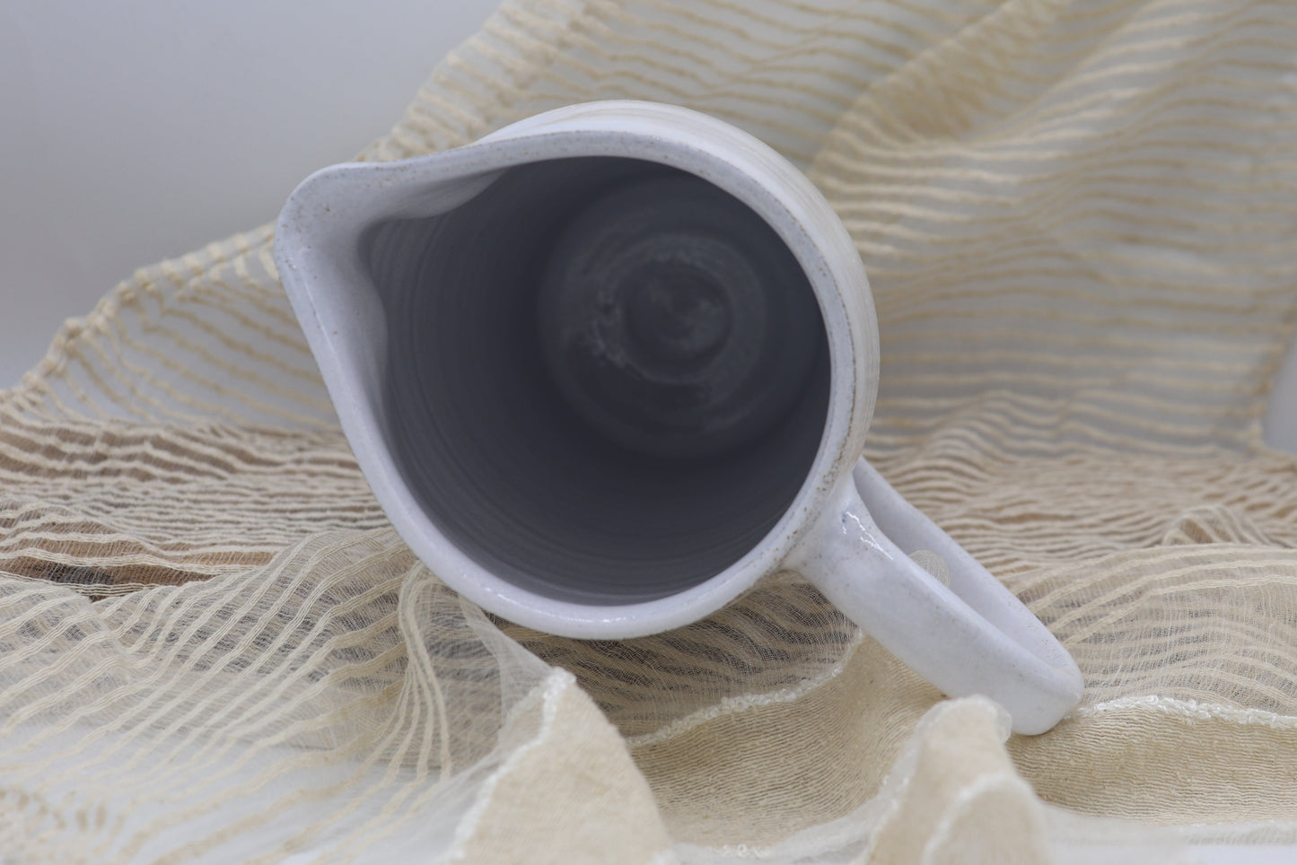 Grey clay pitcher in white