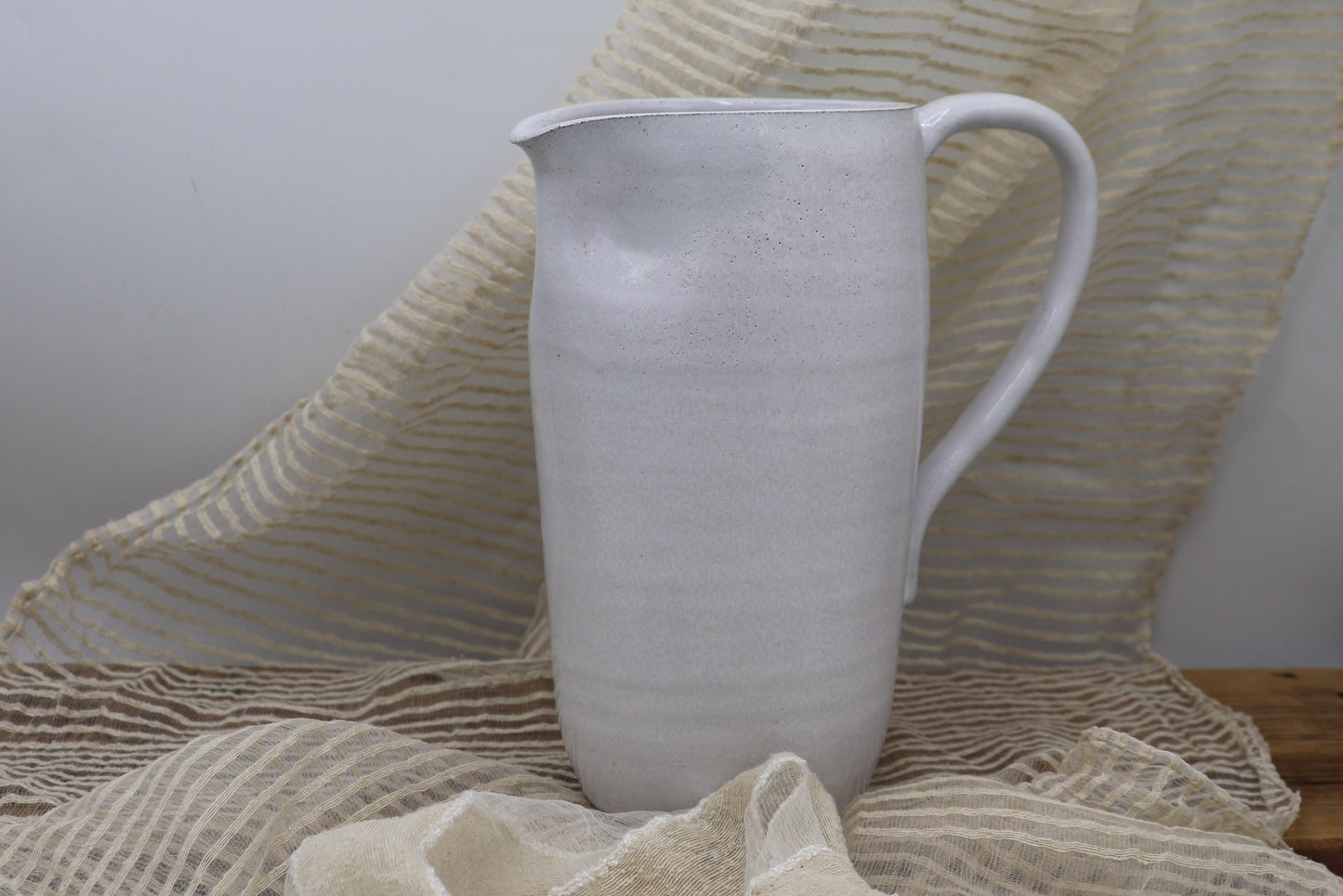 Grey clay pitcher in white