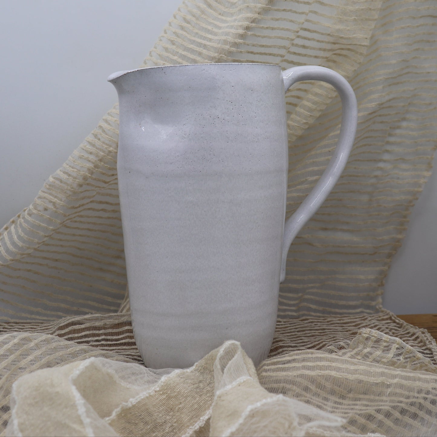 Grey clay pitcher in white