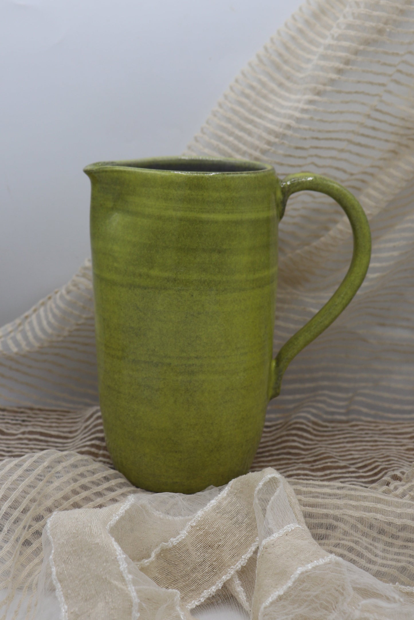 Grey clay pitcher in yellow