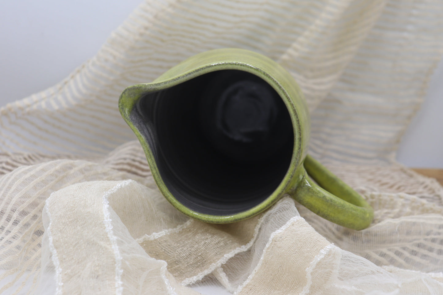 Grey clay pitcher in yellow