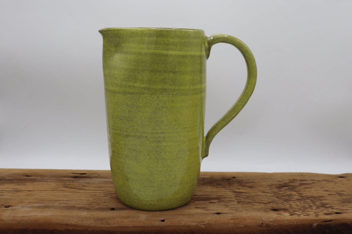Grey clay pitcher in yellow
