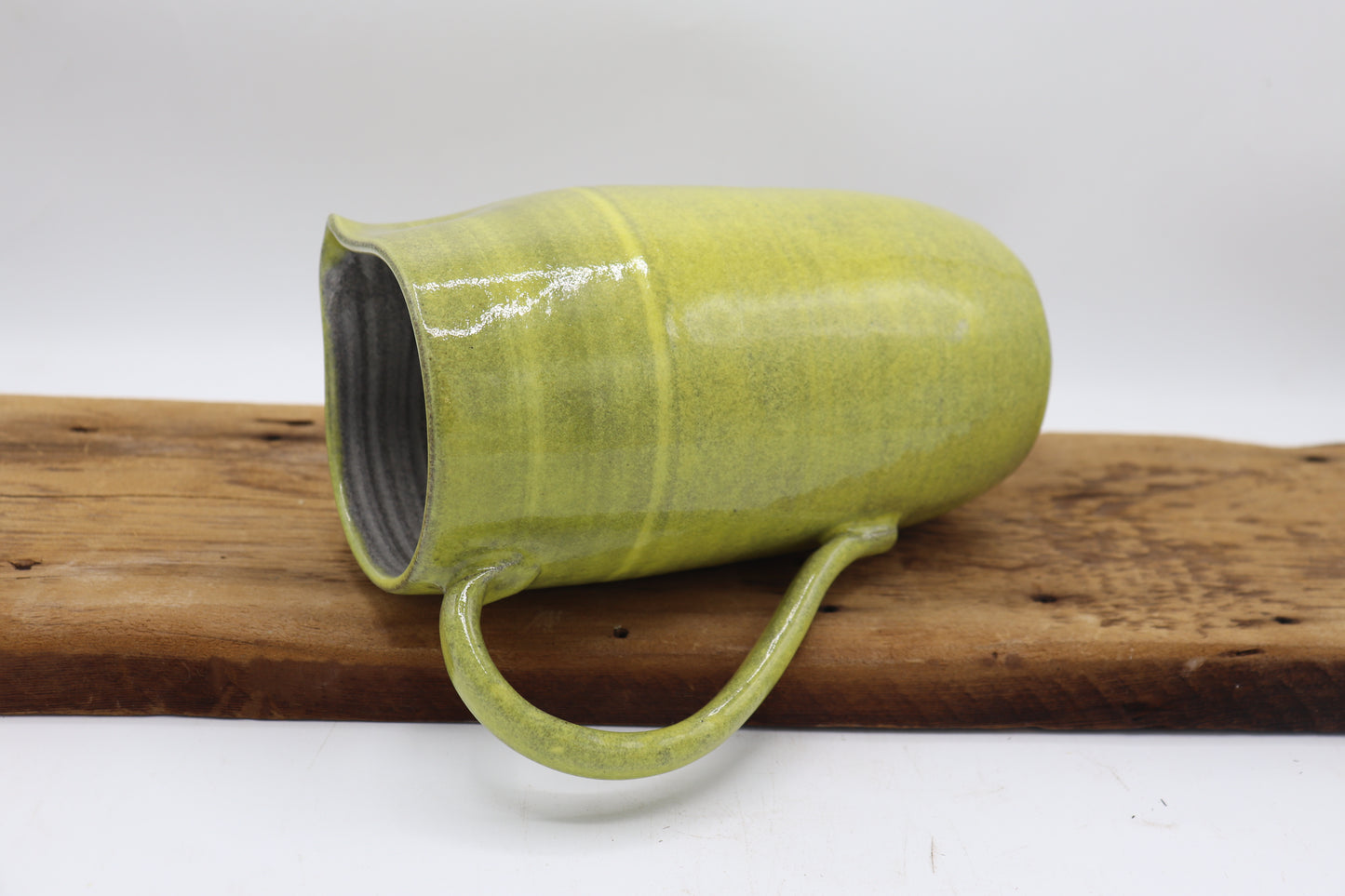 Grey clay pitcher in yellow